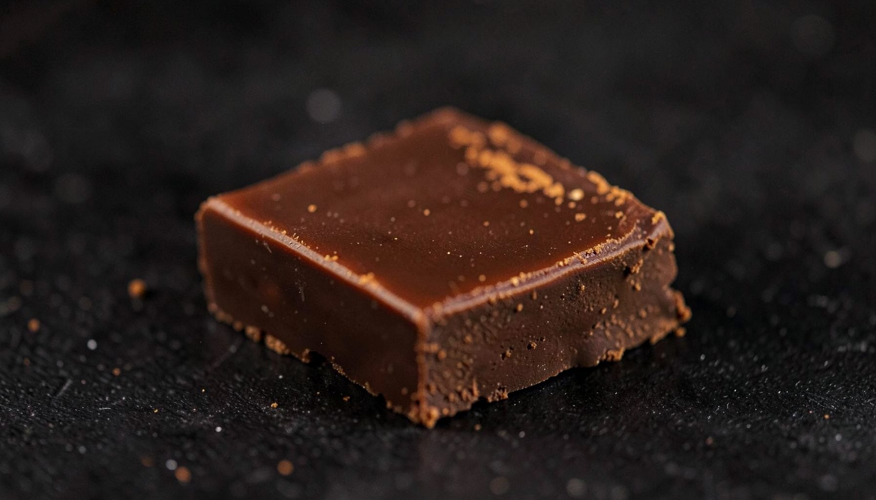 Rich brown and warm spice-toned chocolate bar on a dark surface, cozy and aromatic