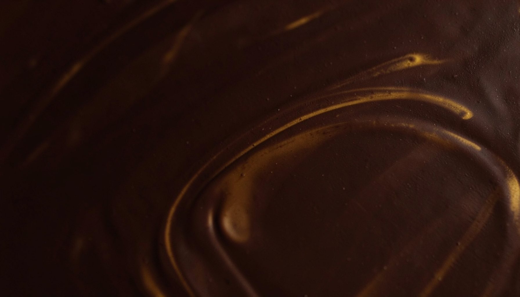 Rich dark chocolate tones with soft golden-brown swirls, warm and indulgent atmosphere