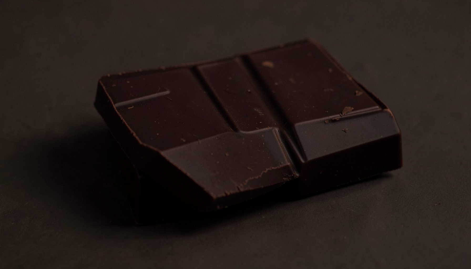 Deep dark brown chocolate bar with a rich, intense, moody color palette